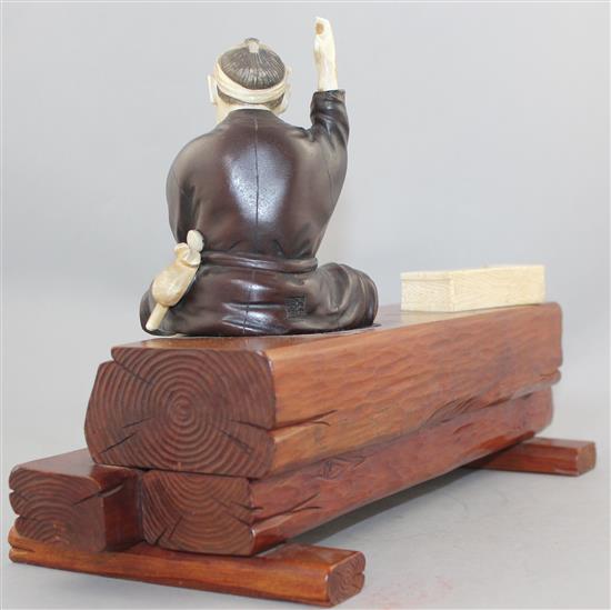 A Japanese ivory, bronze and wood okimono of a carpenter, early 20th century, 32.5cm., some losses